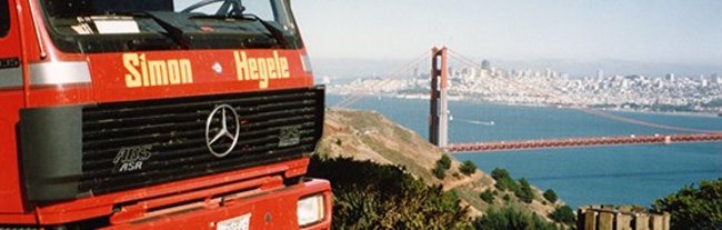 Ein LKW mit der Aufschrift "Simon Hegele" steht auf einer Erhöhung vor der Golden Gate Bridge